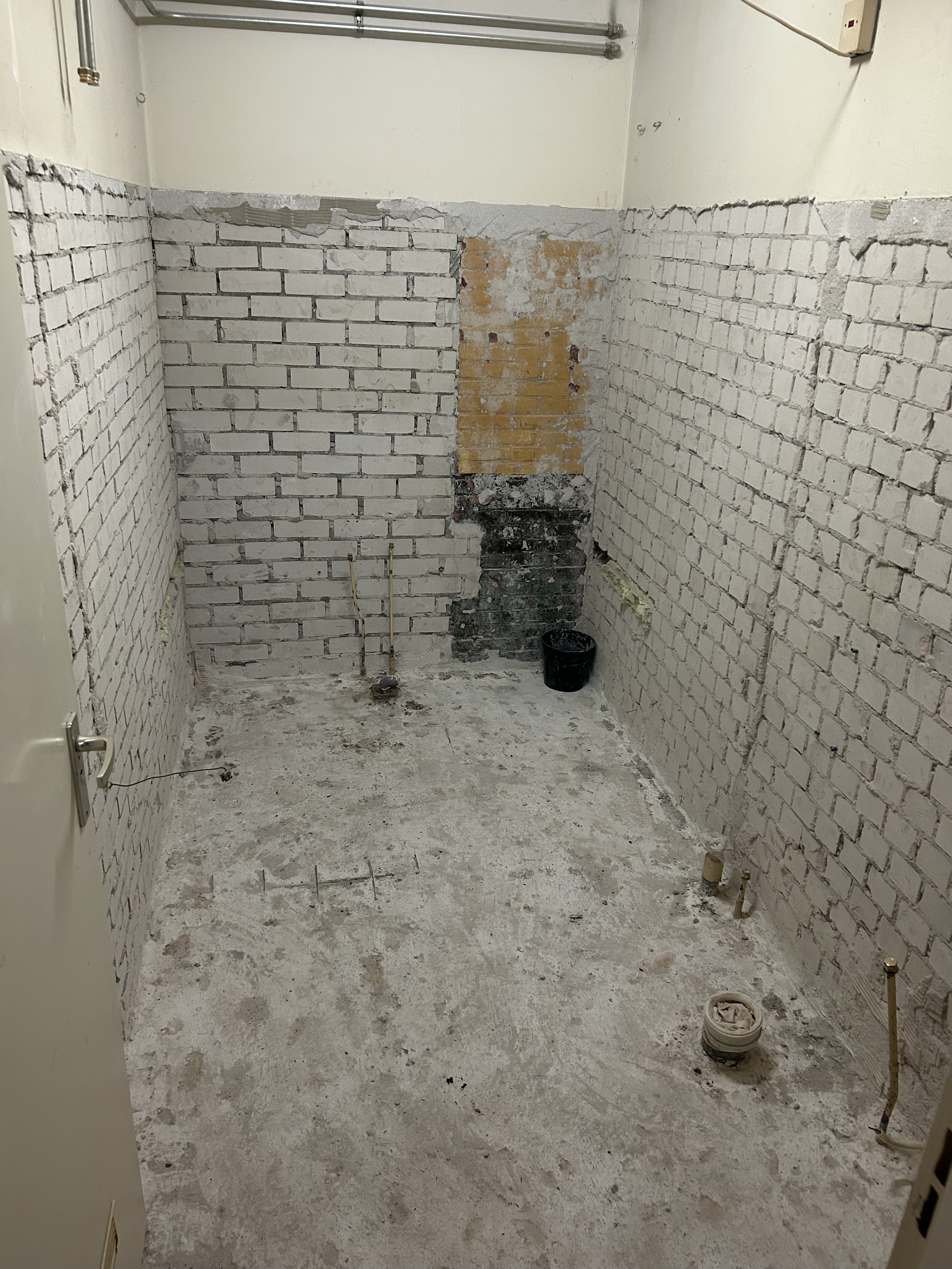 Badkamer na sloop, muren tot op baksteen kaalgezet.